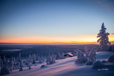 the sun is setting over a snowy landscape