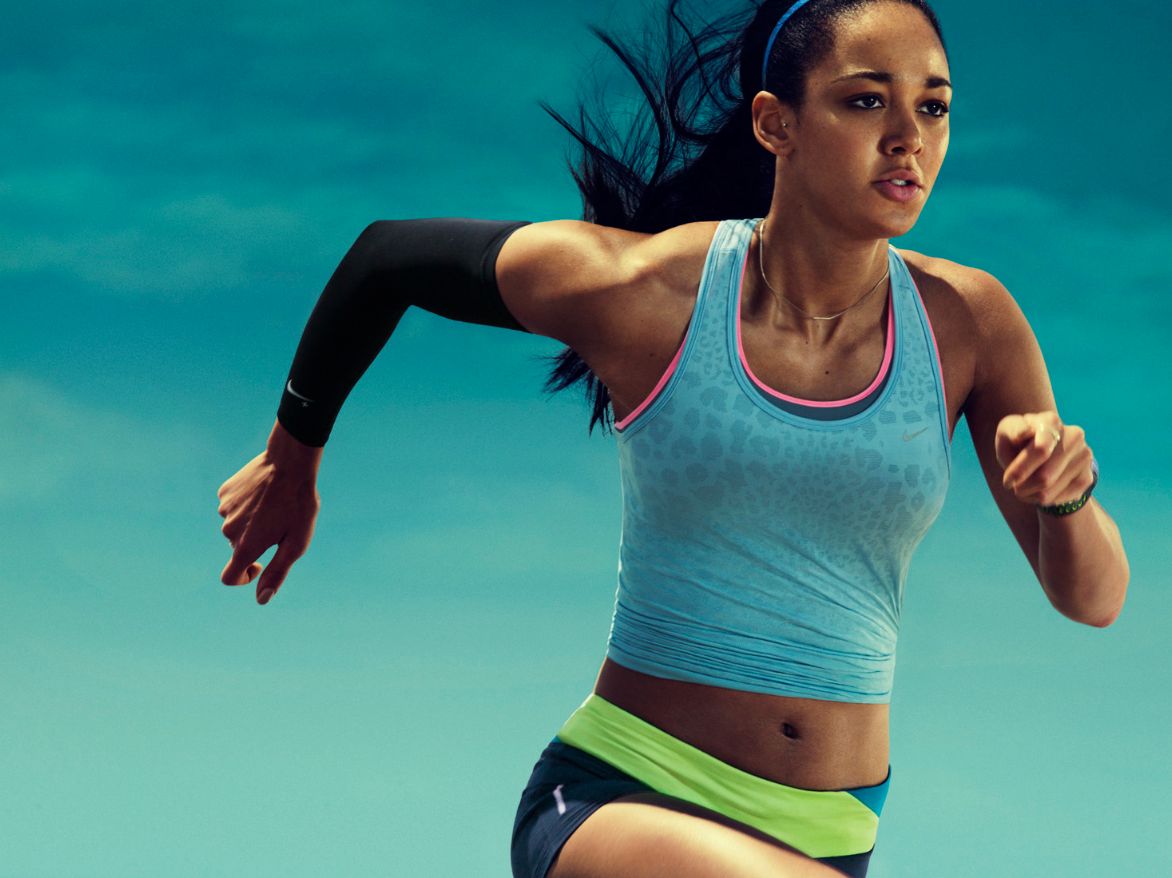 a woman in a blue tank top is running