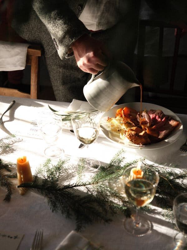 a person pouring a cup of tea over a plate of food