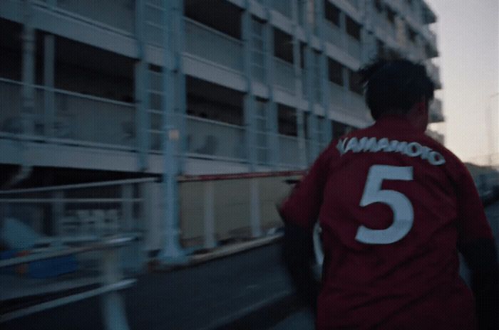 a man in a red shirt walking down a street