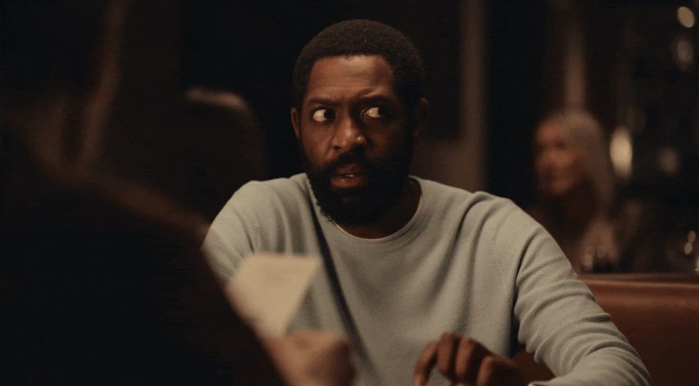 a man sitting at a table with a book in front of him