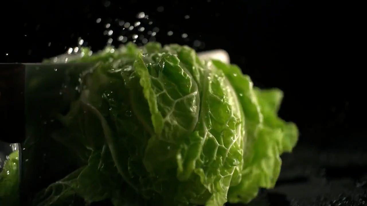 a lettuce being cut into pieces with a knife