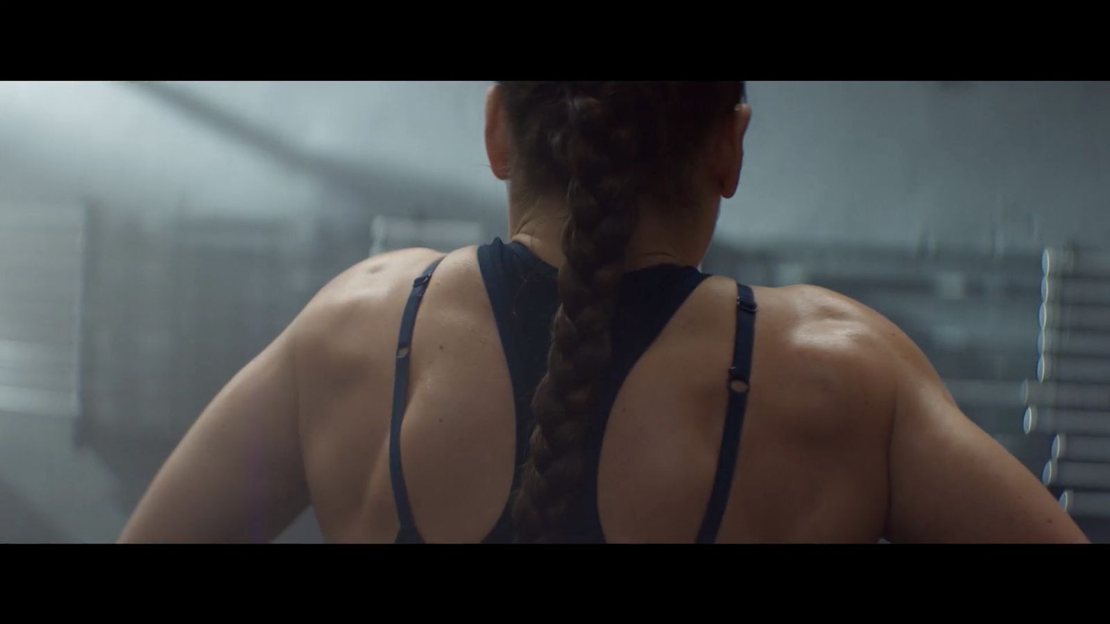 a woman with a braid standing in front of a mirror