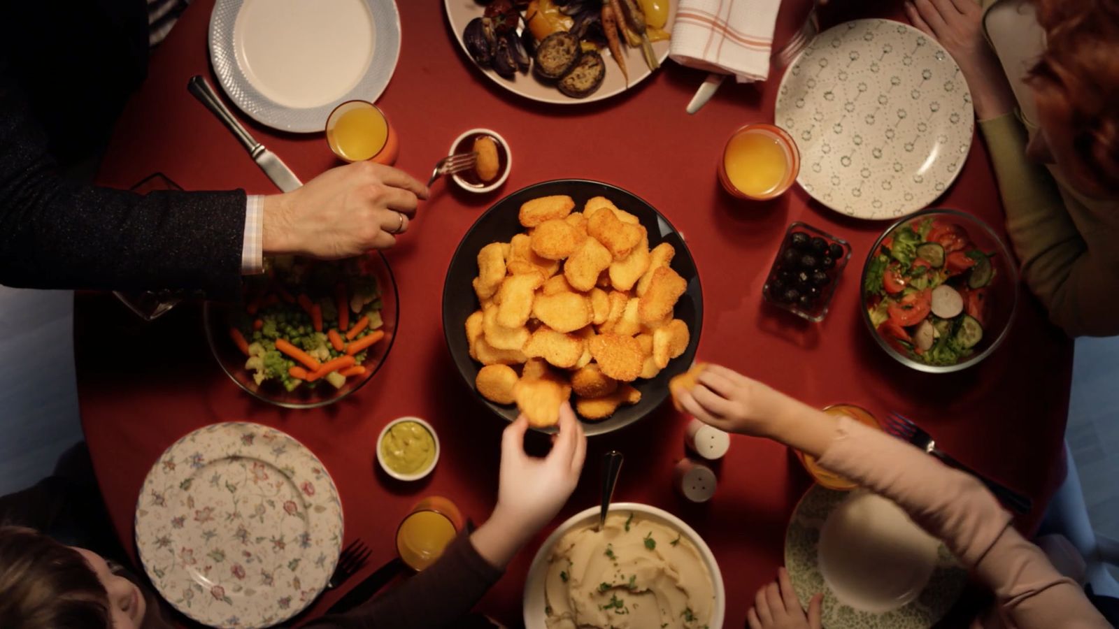 a group of people sitting around a table with food