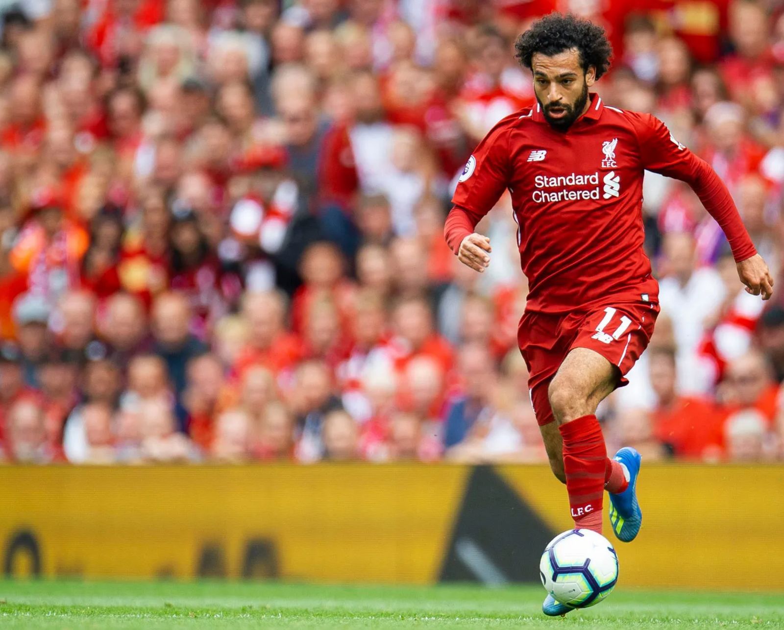 a man in a red uniform kicking a soccer ball