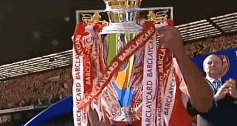 a man holding a trophy in front of a crowd