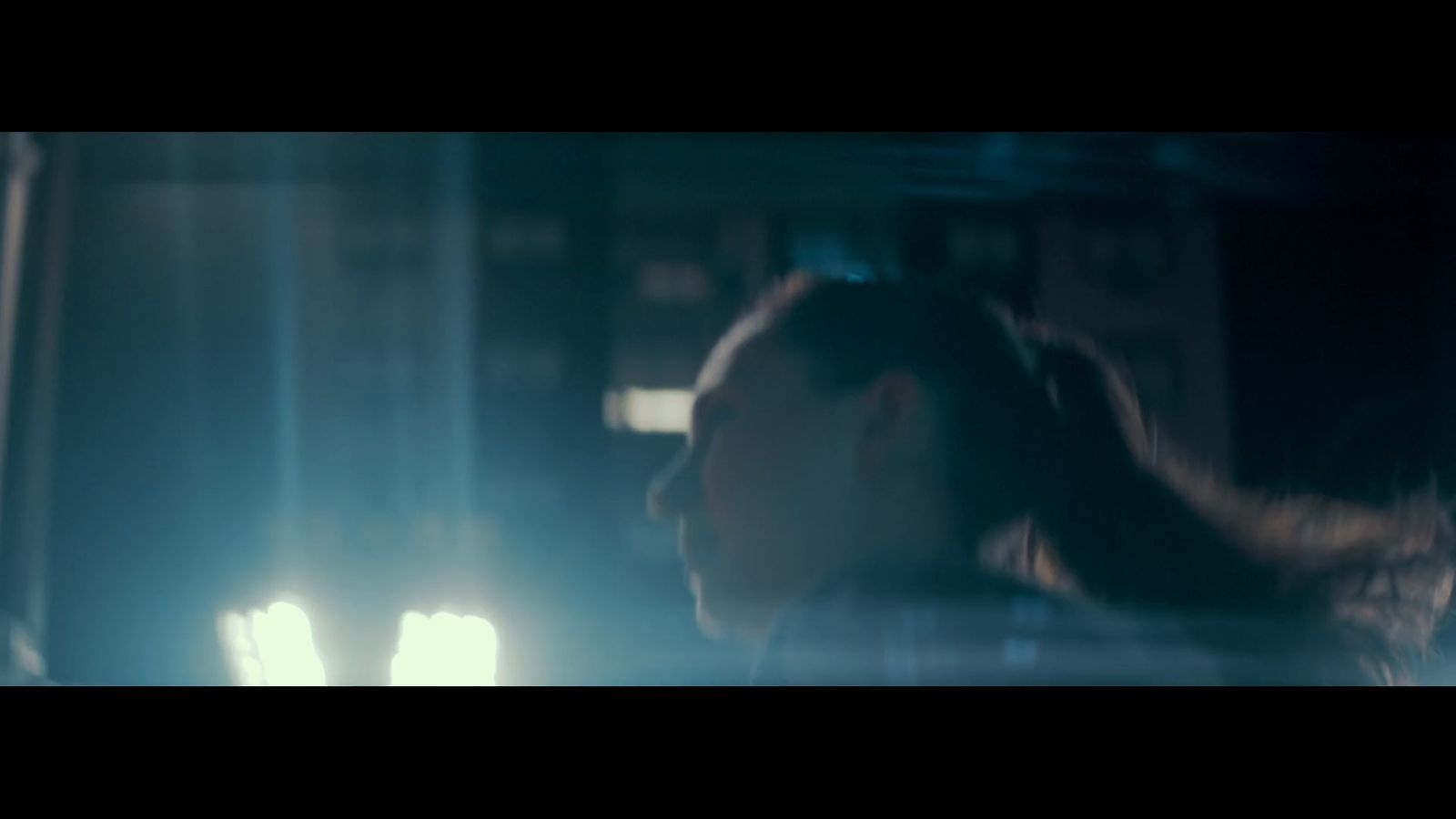 a woman with long hair standing in a dark room