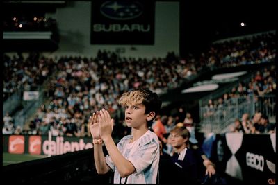 a young man holding a tennis racquet on top of a tennis court