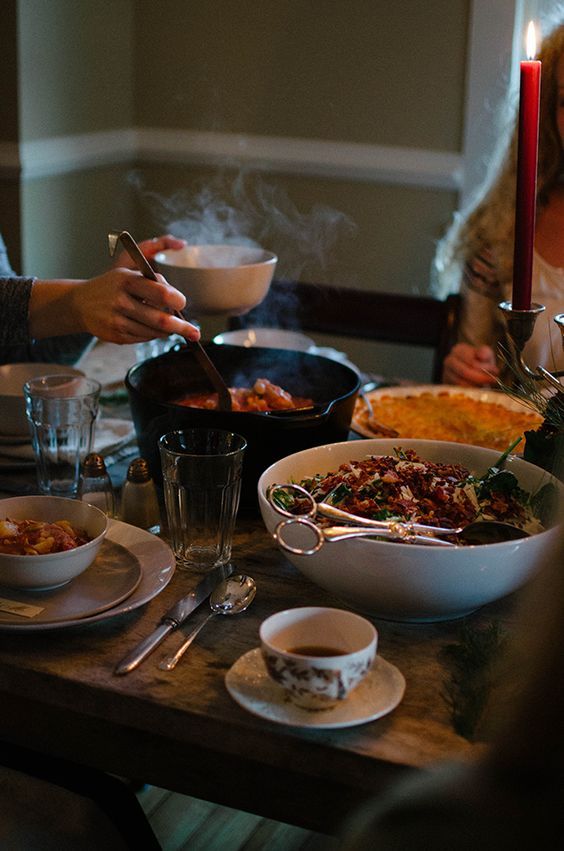 a group of people sitting around a table with food