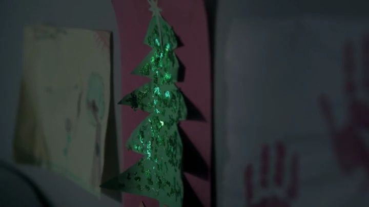 a green christmas tree hanging on a wall