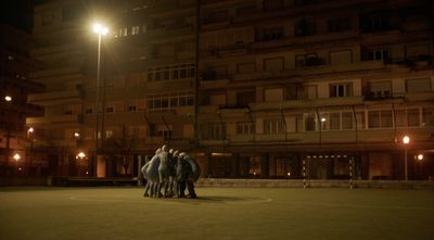 a group of people standing around a basketball court