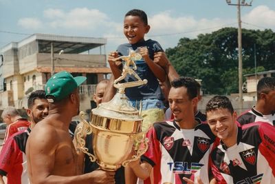 a group of young men standing around a trophy