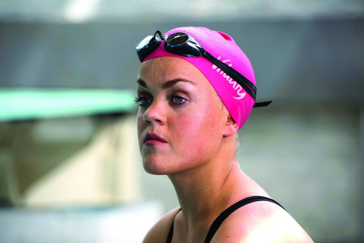 a woman wearing a pink swimming cap and goggles