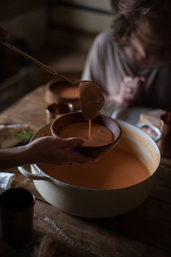 a person pouring melted chocolate into a bowl