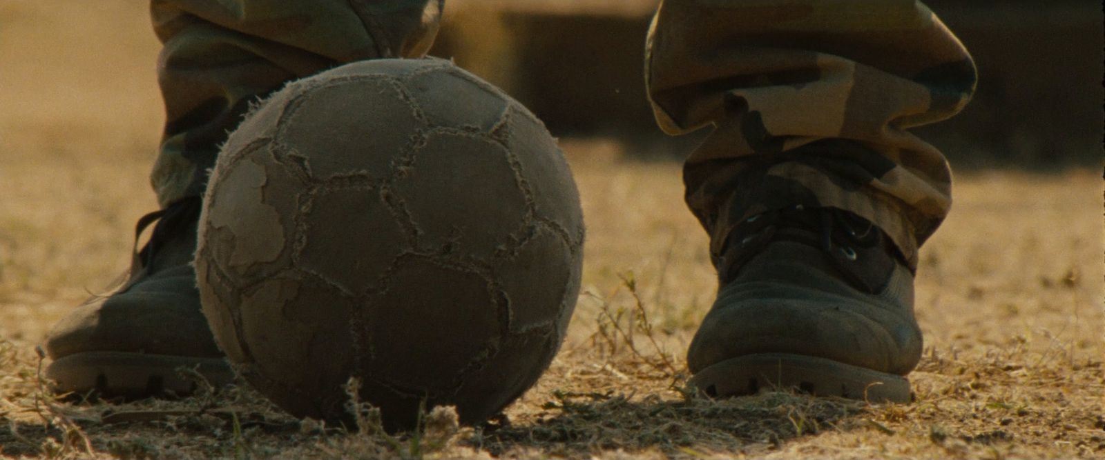 a person standing next to a ball in a field