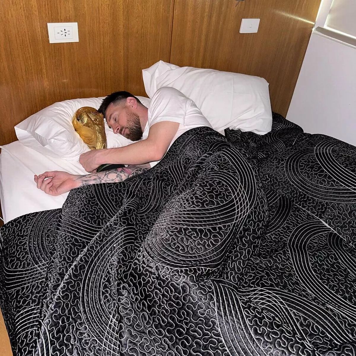 a man laying in bed with a stuffed animal