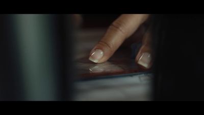 a woman's hand touching a tablet computer screen