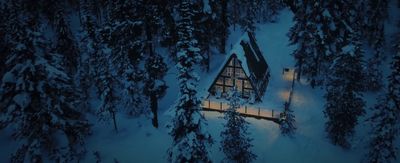 a cabin in the middle of a snowy forest