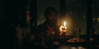 a man sitting at a table with a candle in his hand