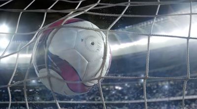 a soccer ball sitting in the net of a soccer field