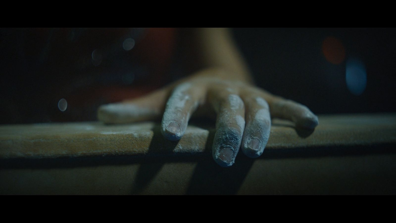 a person's hand resting on a table in the dark