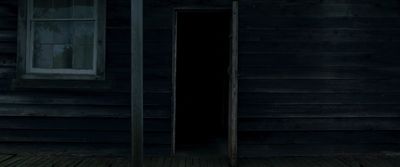 an open door to a dark wooden house