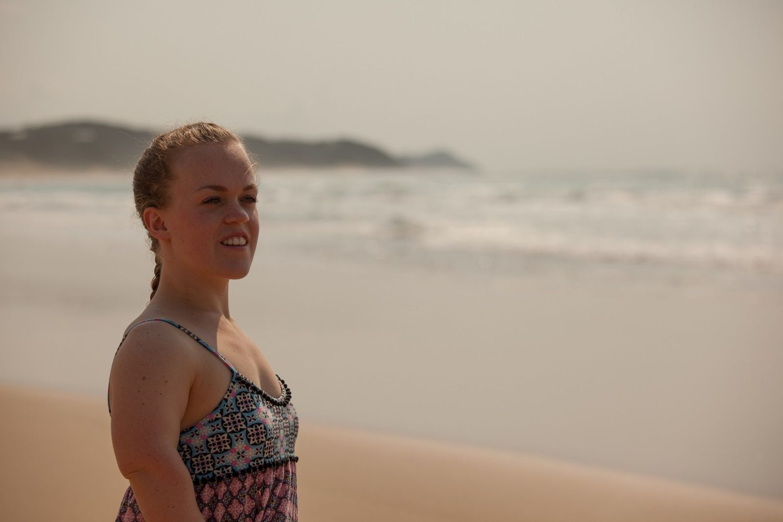 a woman standing on a beach next to the ocean