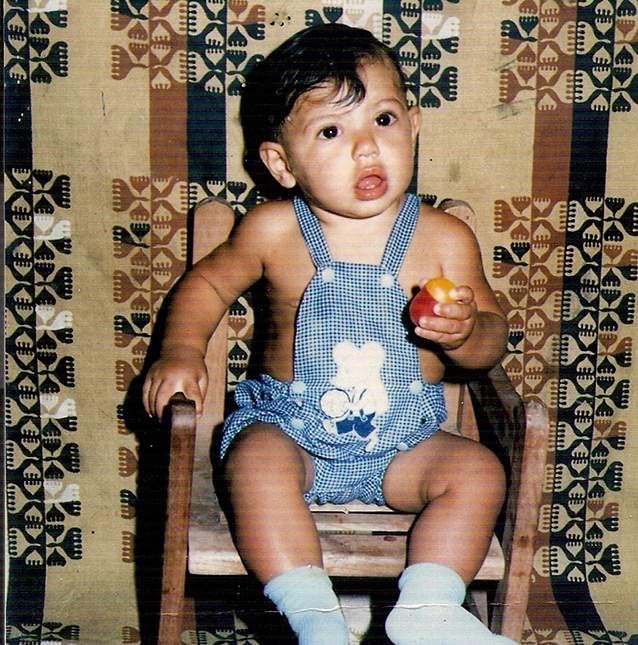 a baby sitting in a chair holding an apple