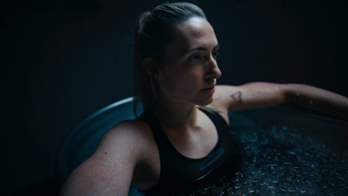 a woman in a black tank top sitting in a tub