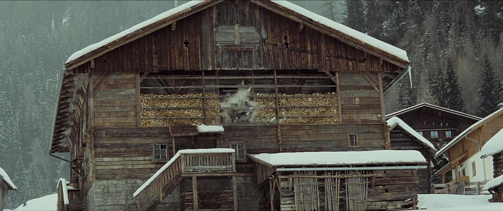 an old wooden building with snow on the ground