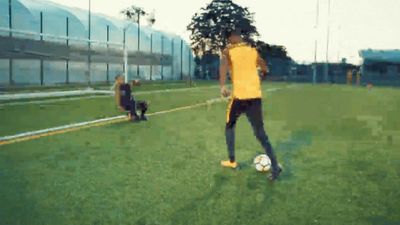 a man in a yellow shirt kicking a soccer ball