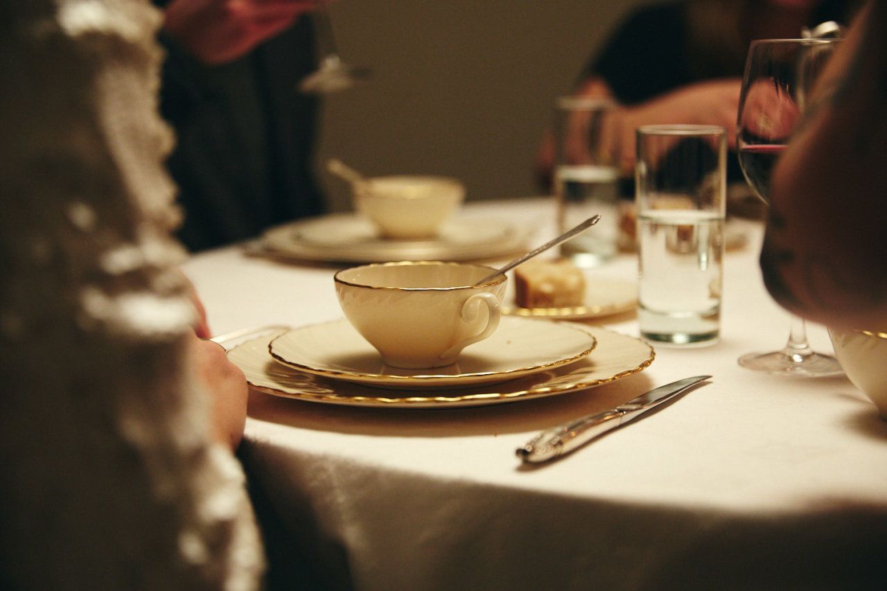 a woman sitting at a table with a cup and saucer