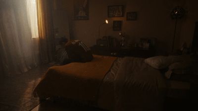 a dimly lit bedroom with a bed and a window