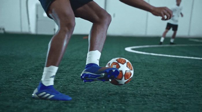 a man kicking a soccer ball on top of a field