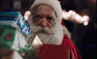 a man with a beard and glasses holding presents