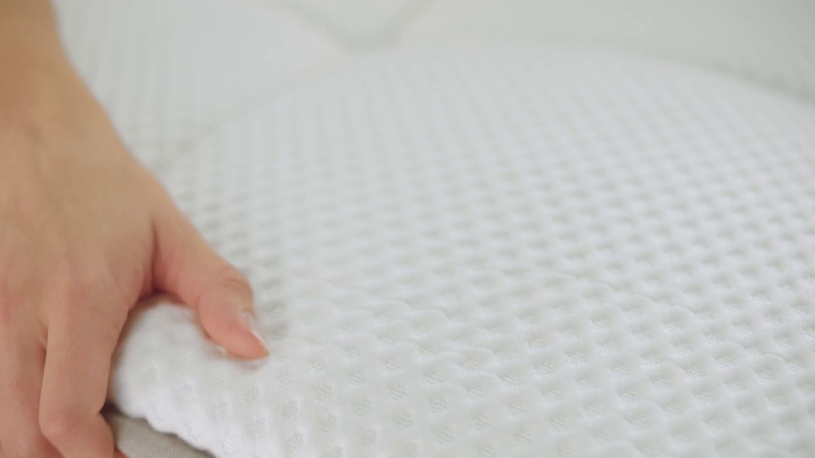 a person's hand on a pillow on a bed