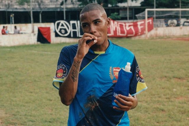 a man holding a toothbrush and a bottle of toothpaste