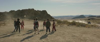 a group of people standing on top of a dirt field