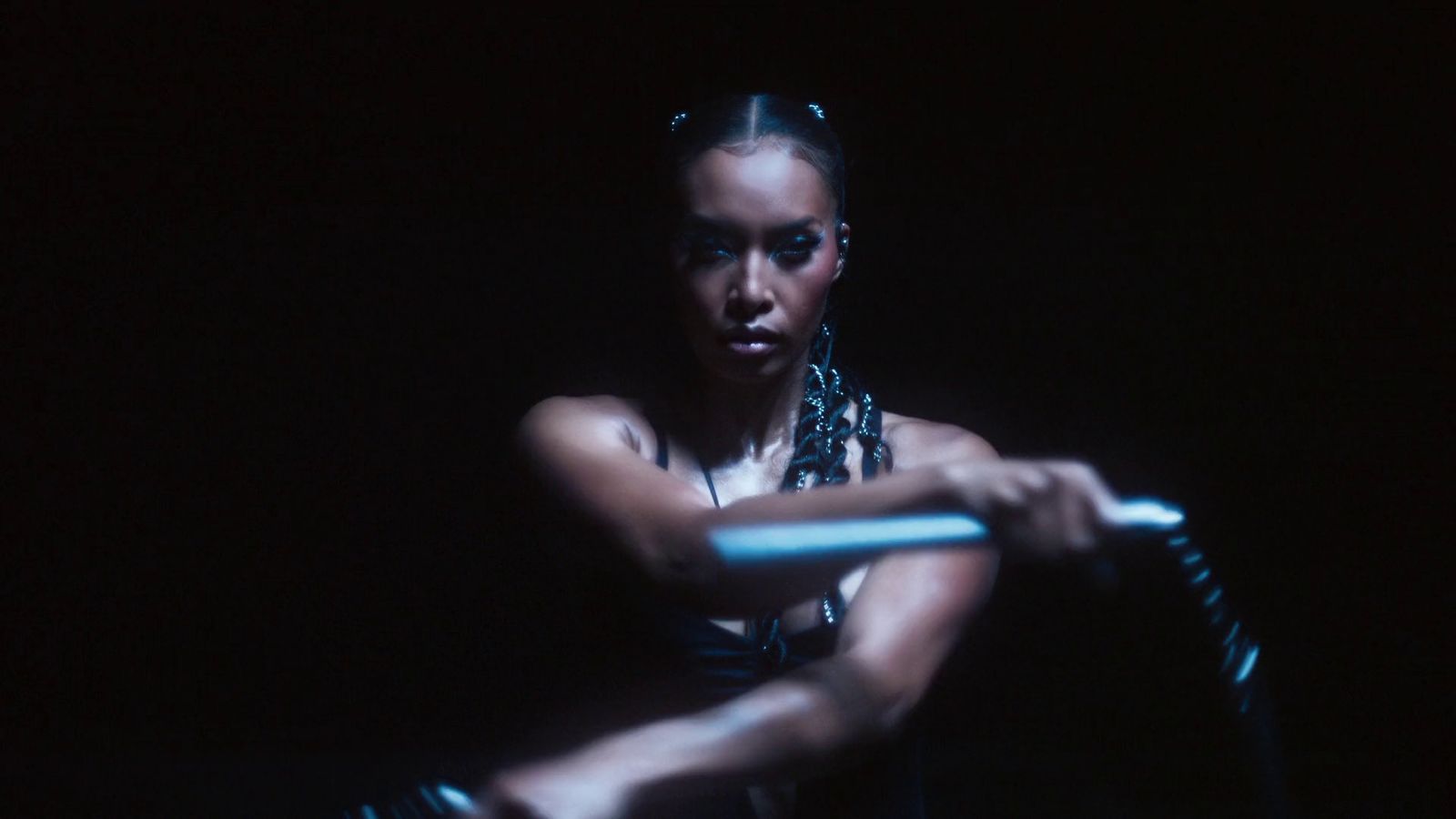 a woman holding a baseball bat in the dark