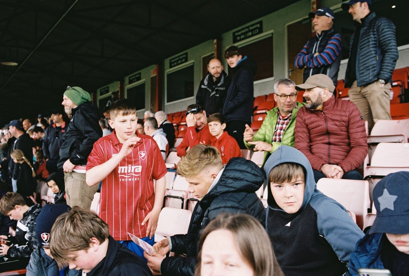 a group of people sitting in a stadium next to each other