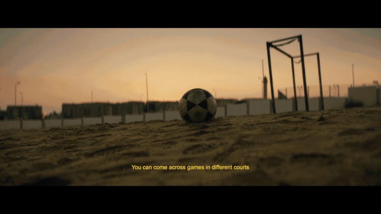 a soccer ball sitting on top of a sandy field