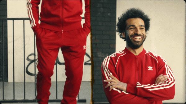 a man in a red adidas outfit standing next to a man in a red