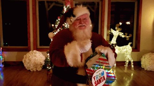 a man dressed as santa clause holding a box