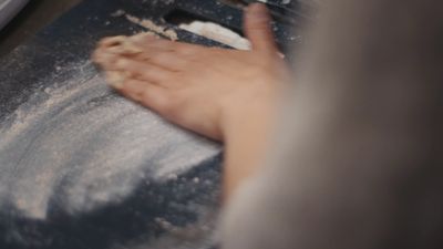 a close up of a person kneading dough