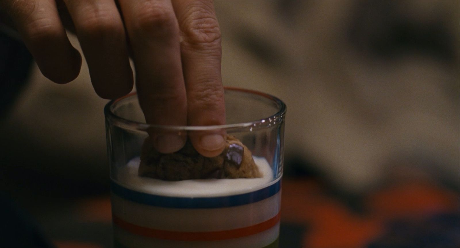 a person putting a rock in a glass of milk