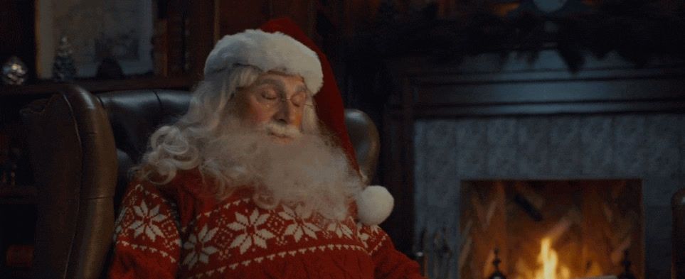 a santa clause sitting in front of a fire place