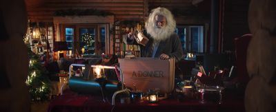 a man with a long white beard standing in front of a table