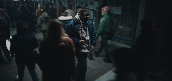 a group of people walking down a street at night