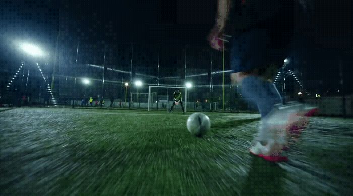 a person kicking a soccer ball on a field