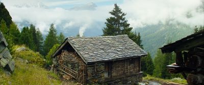 a cabin in the middle of a mountain range